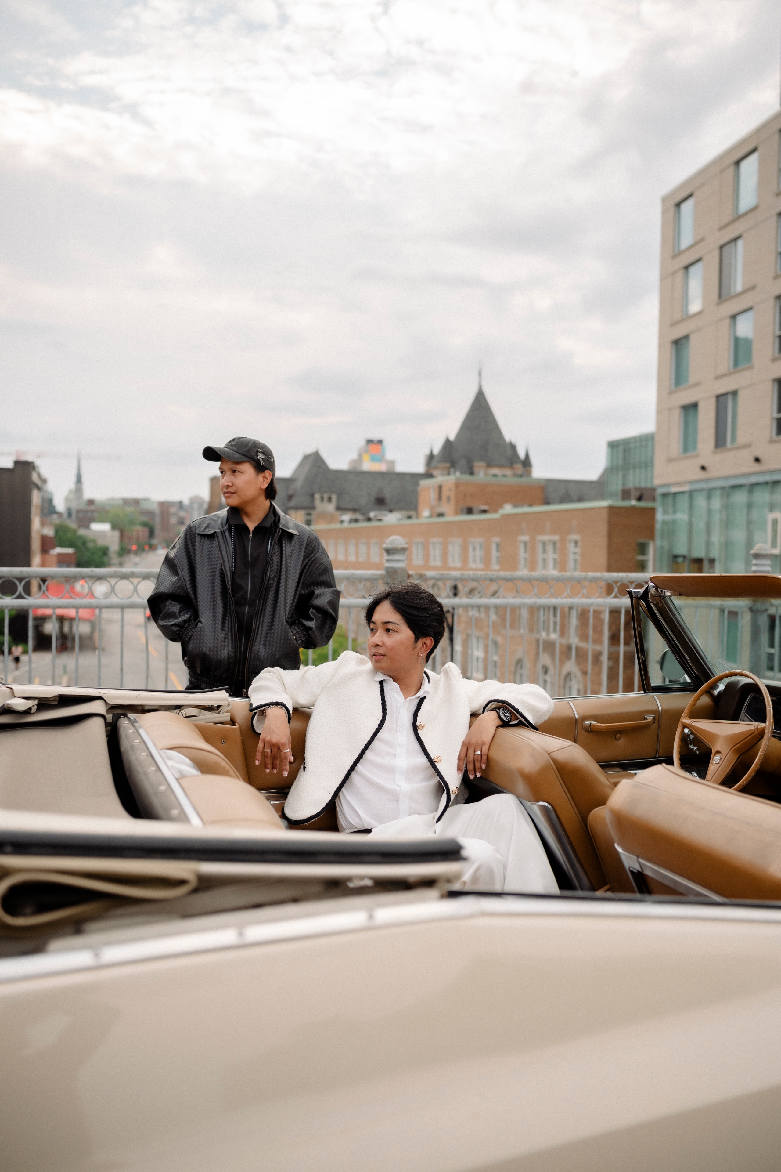 couple posing in vintage convertible Cadillac rooftop Montreal skyline engagement
