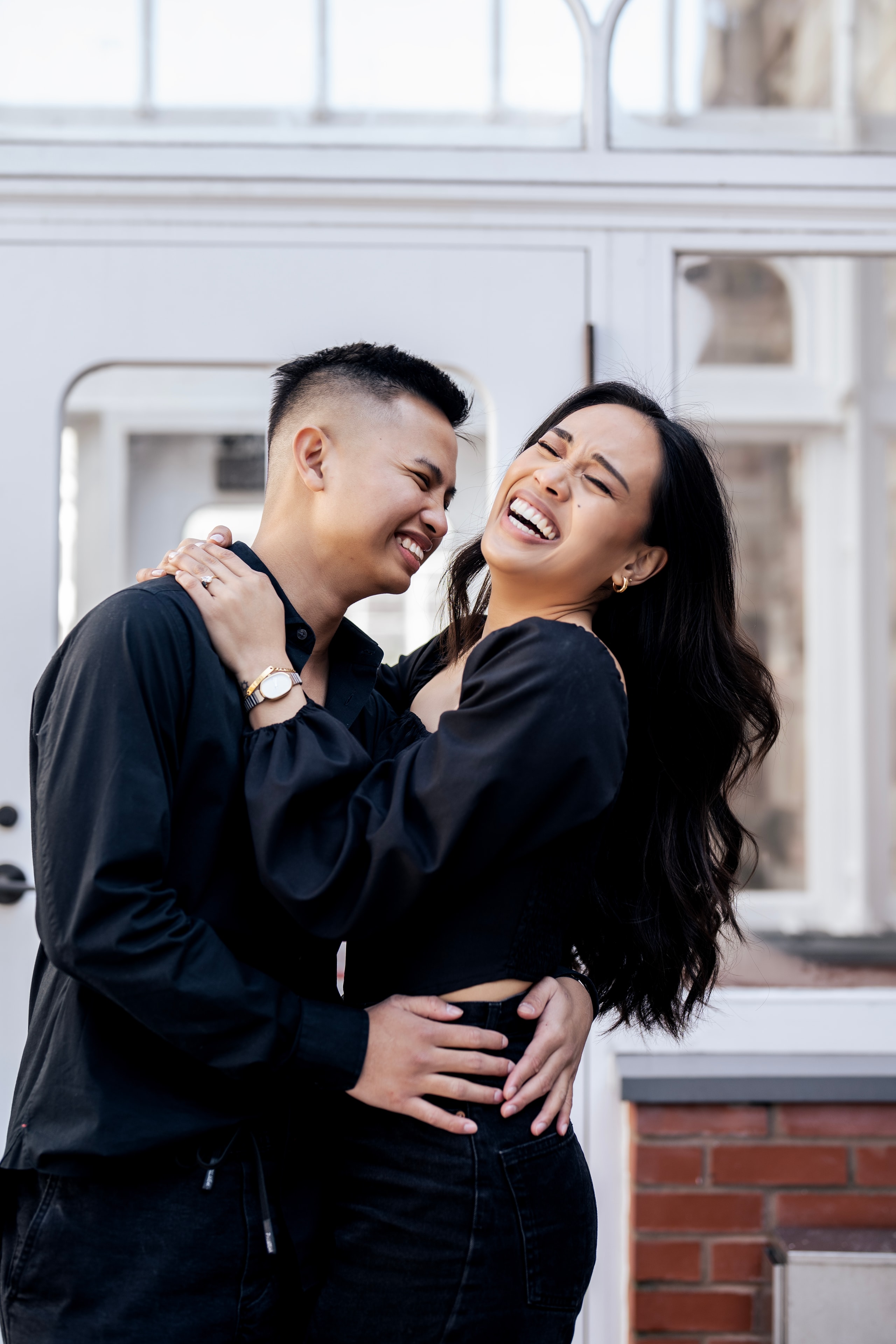 engagement couple in black laughing urban setting