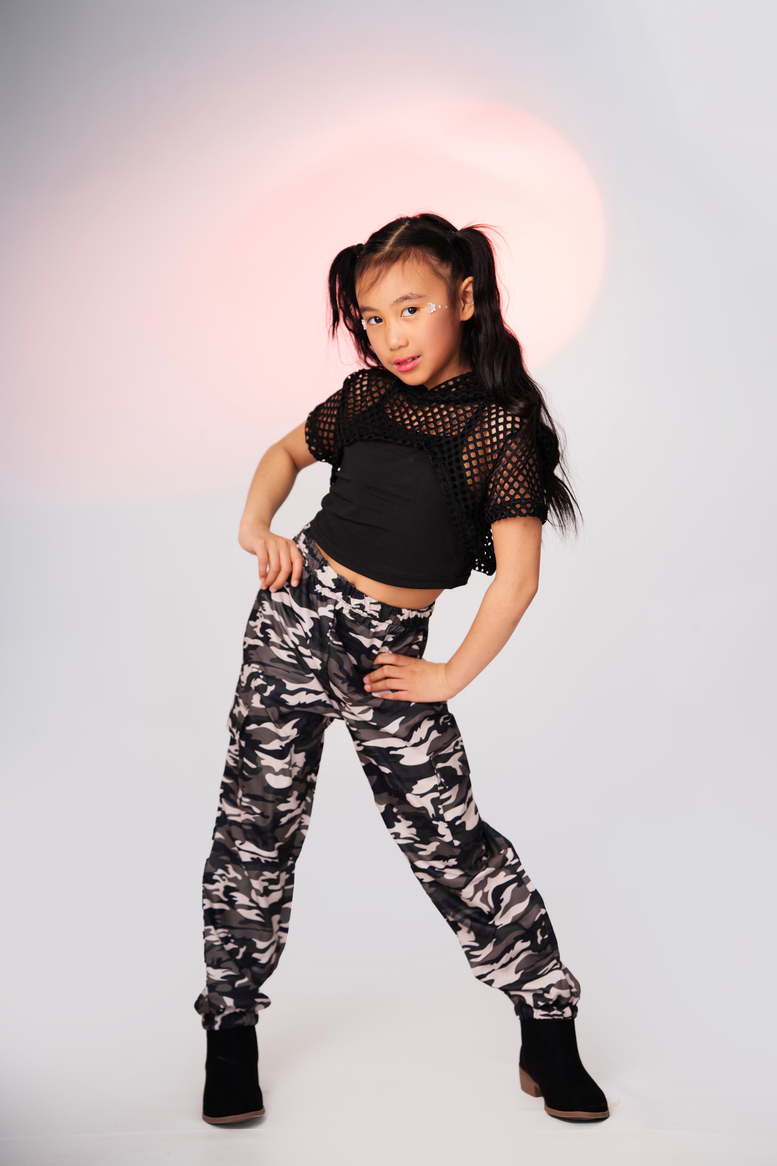 girl in camo pants hip hop dance pose studio portrait