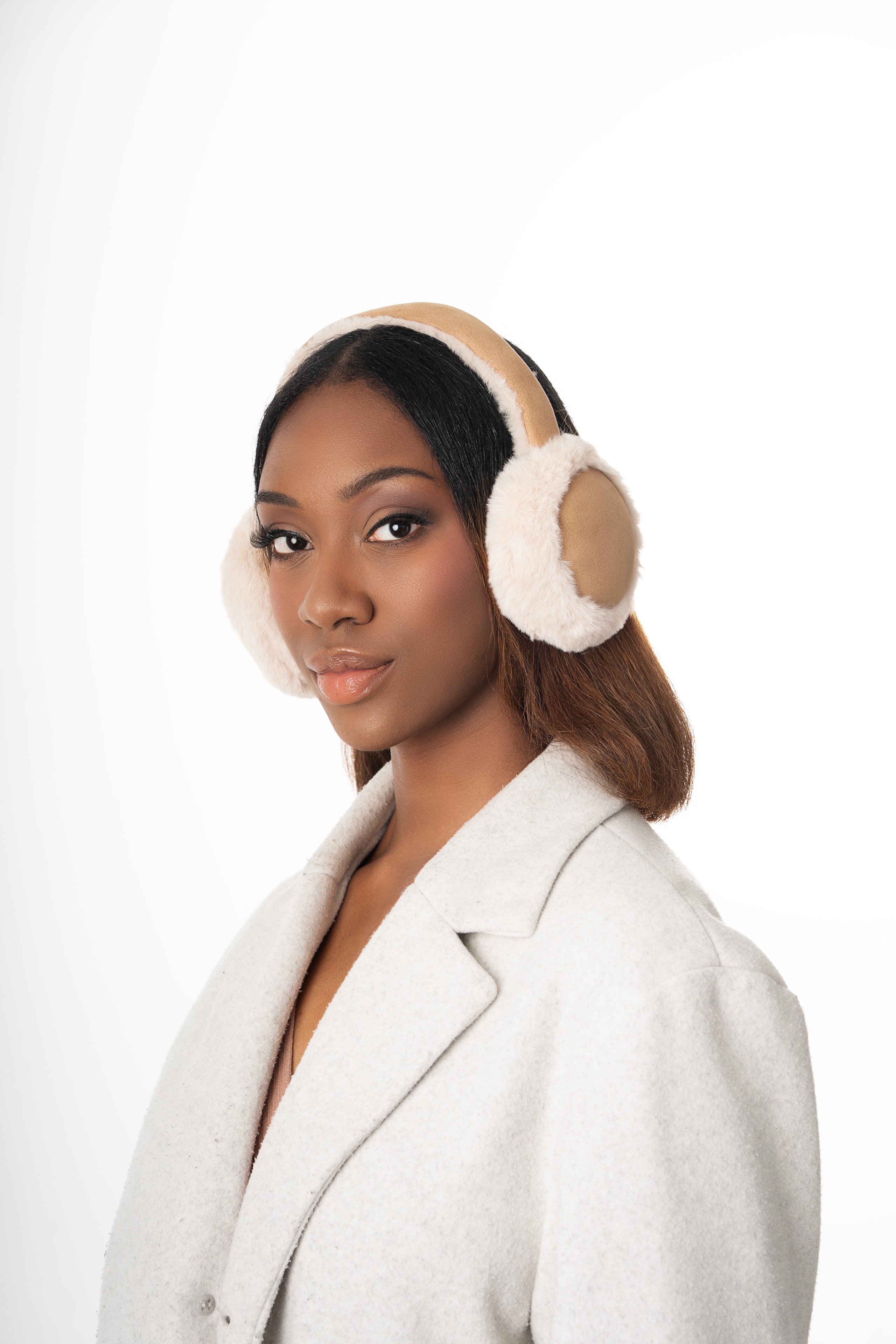 woman wearing fur earmuffs white coat white background product photography